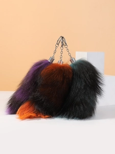 Detailed close-up of large multicolor faux fur fox tail keychain with silver metal clip