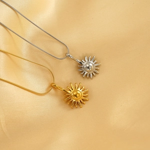 Elegant 18k gold and silver plated sun pendant necklaces on silk satin background