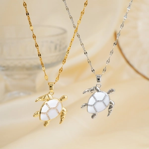 Fashionable gold and silver turtle pendant necklaces with white inlay on a soft background
