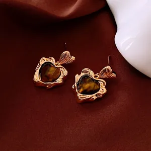 Boucles d'oreilles cœur vintage avec œil de tigre et plaqué or sur fond de velours chaud