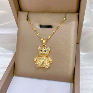 Close-up of a sparkling gold teddy bear pendant set in a premium jewelry display box
