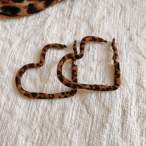 Vue détaillée de boucles d'oreilles cœur léopard avec texture douce et clous en argent