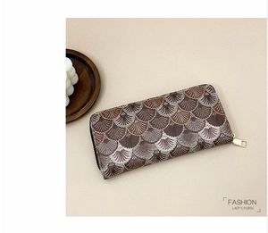 Detail of embroidered scale pattern on women's long wallet with golden zipper
