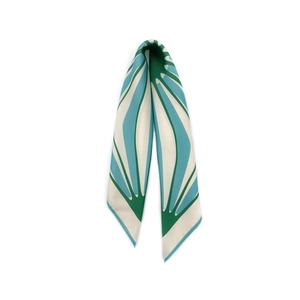 Detail of silk-like neck scarf showing green and blue geometric pattern and smooth texture