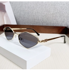 Detail of trendy gold metal geometric cat eye sunglasses on a minimalist white stand