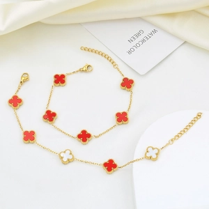 Detail view of gold-plated star clover bracelets with red and white beaded edges