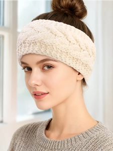Close-up of beige cable knit headband on a model, showing the soft wool texture and pattern