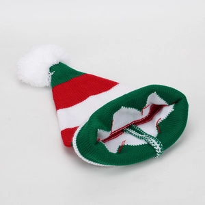 Detail of red and green striped Christmas knit hat with large white fluffy pompom ball