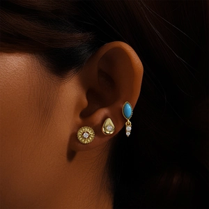 Close-up van driedelige set S925 zilveren turquoise oorbellen met gouden finish