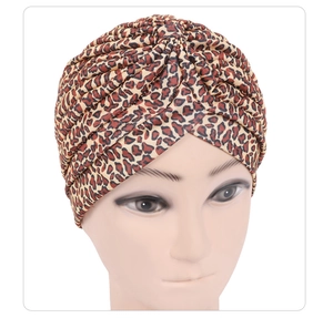 Detailed close-up of pleated leopard print turban hat on model head with elastic fabric