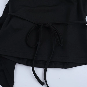 Détail du haut noir à épaules dénudées avec ourlet à volants et lien de serrage à la taille
