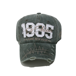 Detailed view of the distressed 1985 embroidery and worn denim fabric on the baseball cap