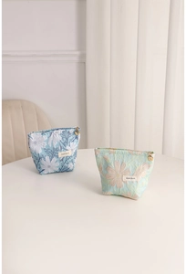 Macro detail of blue and green woven floral cosmetic bags with sturdy metal zippers