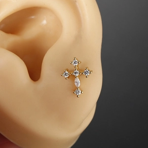Gold stainless steel cross stud earring with white zircons on a silicone ear model