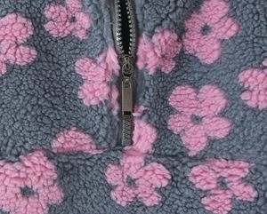 Detail of grey sherpa hoodie with pink floral pattern and durable metal zipper closure