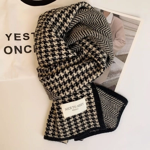 Classic black and white houndstooth knit scarf with minimalist brand label for winter