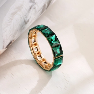 Detailed view of emerald cut green crystal gems in golden alloy claw settings