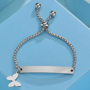 Close-up of silver box chain bracelet with butterfly charm and engravable curved plate