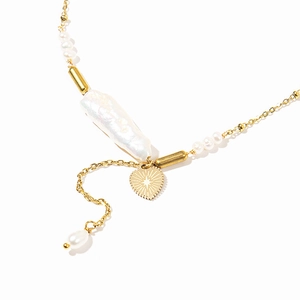 Baroque pearl necklace with golden heart pendant featuring a sunburst engraving