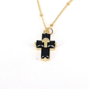 Hip hop gold cross necklace with black stones on white background, urban jewelry style
