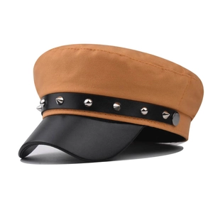Dettaglio del berretto baker boy con borchie argentate e visiera in pelle nera