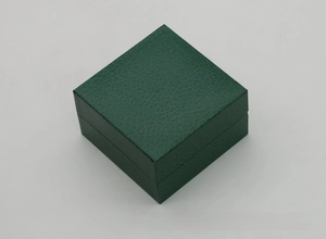 Macro view of dark green faux leather watch box with a textured lychee grain finish