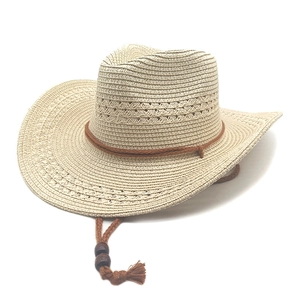 Detail of woven straw cowboy hat with ventilated texture and beaded chin strap