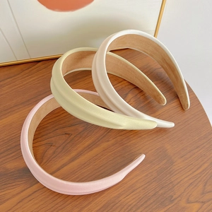 Detailed texture of fabric wide headbands in pink, beige, and cream colors