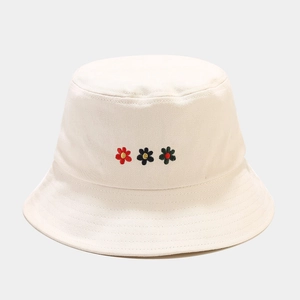 Detail of three small floral embroideries on white cotton canvas fisherman sun hat