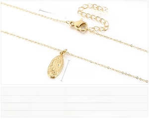 Detailed macro view of gold Virgin Mary pendant on stainless steel chain with size specs