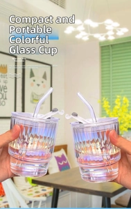 Iridescent ribbed glass coffee cup with glass straw and leak-proof lid in hand