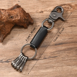 Vintage black leather keychain for men with rotating spring hook and metal rings on wood