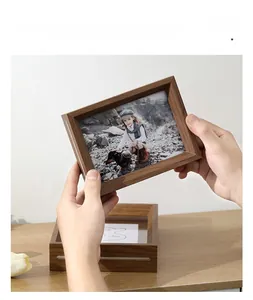 Detail of walnut solid wood picture frame held by hand in a minimalist home office setup