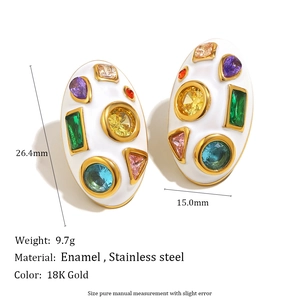 Vue macro de boucles d'oreilles ovales plaquées or 18 carats avec émail blanc et zircons