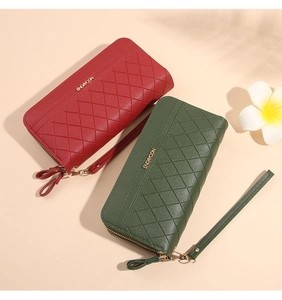 Red and green quilted long wallets with dual gold zippers and wristlets in macro view