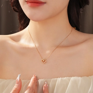 Close-up of 18K gold-plated clover necklace with sparkling cubic zirconia on a model