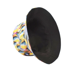 Detail of 3D tie-dye bucket hat showing yellow-blue print and black reversible side