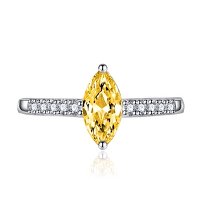 Macro shot of marquise cut yellow gemstone ring with pavé side diamonds on silver band