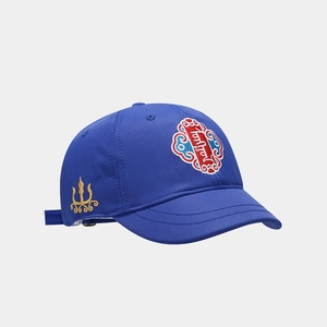Dettaglio del cappellino blu reale con ricamo etnico e motivi dorati laterali