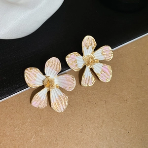 Detail of floral stud earrings featuring pink and white enamel petals with gold finish