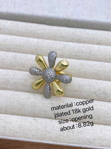 Macro shot of gold and silver daisy ring with cubic zirconia in beige jewelry box