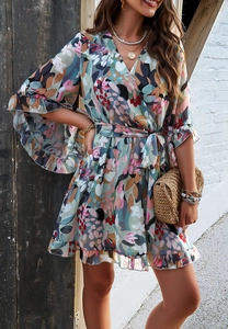 Detail of floral chiffon wrap dress featuring V-neckline and ruffled sleeve hem