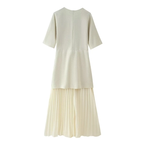 Détails de la robe en maille crème avec jupe plissée et couture à la taille élégante