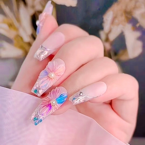 Close-up of 5D floral press-on nails with pink blue gradient and pearl rhinestones