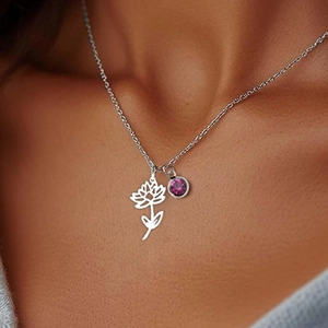 Detail of silver birth flower necklace with purple gemstone on female model's neck