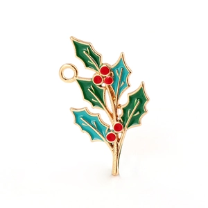 Detail of holly leaf and red berry pendant with gold metal and green enamel inlay
