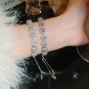 Close-up of heart-shaped pink and white zircon bracelets with adjustable silver sliding clasps
