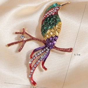Fashionable magpie bird brooch in green and gold finish with sparkling rhinestones