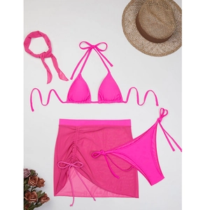 Flat lay of hot pink 4-piece bikini set with mesh skirt, headband and beach accessories
