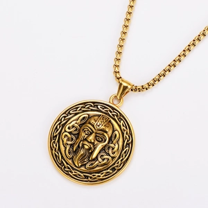 Detail of golden Viking pendant with Celtic knots and embossed face on stainless steel